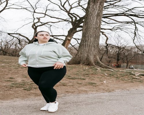 Woman jogging lightly in a beautiful green park